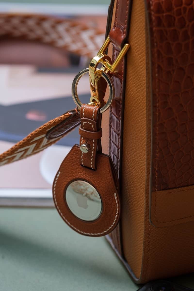 a brown purse with a key chain attached to it