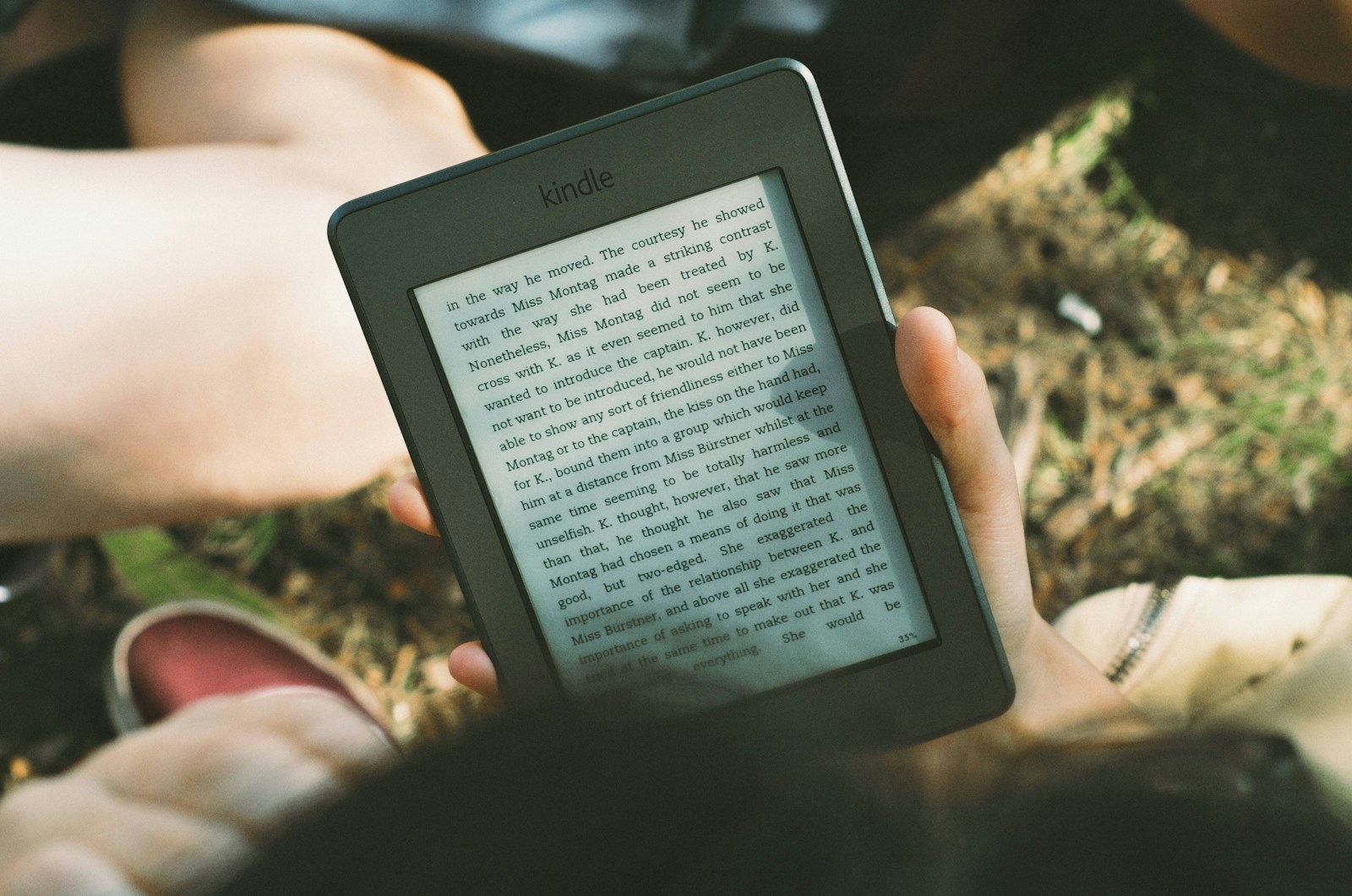 person holding black Amazon Kindle e-book reader